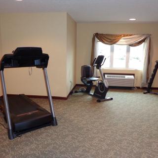 A small indoor gym with a treadmill and stationary bike.