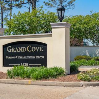 Entrance sign for Grand Cove Nursing & Rehabilitation Center surrounded by well-maintained landscaping.