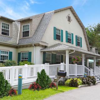 Charming residential house with a front porch and white picket fence.