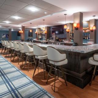 A contemporary bar interior with stylish seating and ambient lighting.