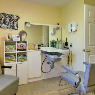 A well-equipped hair salon interior with a chair, sink, and various hair products.