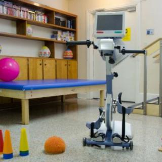 A physical therapy room equipped with rehabilitation equipment including a monitor and exercise tools.