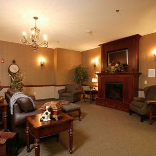 A cozy living room with a fireplace, elegant chandelier, and traditional decor.