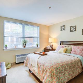 A cozy bedroom interior with a neatly made bed, soft lighting, and decorative elements.