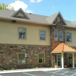A commercial building with a stone facade and parking lot.