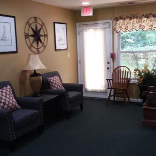 Cozy living room with armchairs, decorative wall art, and a sunlit window.