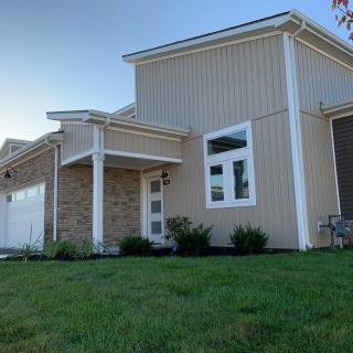 A modern house with a well-maintained lawn under a clear blue sky.