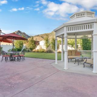 A peaceful backyard patio with a gazebo and outdoor seating.