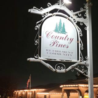 A lit sign for Country Pines restaurant seen at night.