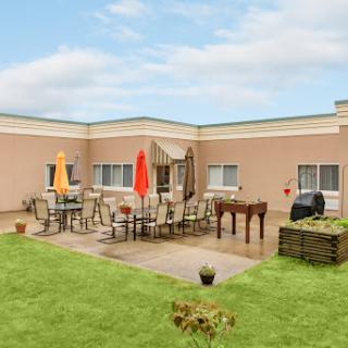 A cozy outdoor patio area with furniture and greenery.