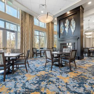 A modern dining area with elegant decor, featuring large windows and stylish furnishings.