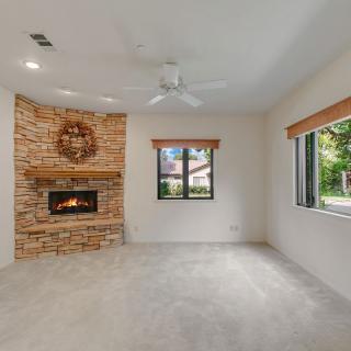 A cozy living room with a brick fireplace and large windows.