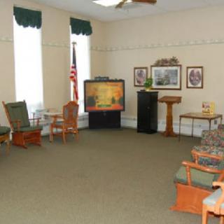 A small meeting room with chairs, a television, and decor.
