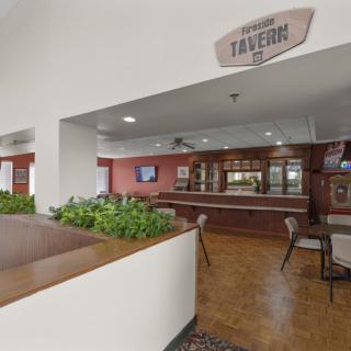 Interior view of a tavern with seating areas and a bar.