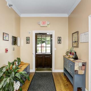 A cozy hallway with wooden flooring and decorative elements including plants and artwork.