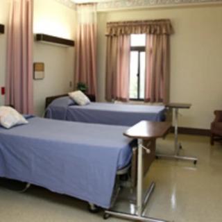A hospital room with two patient beds and medical equipment.