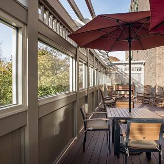 Cozy outdoor patio with tables and umbrellas on a wooden deck.
