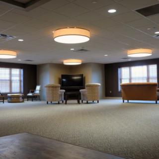 A spacious and well-lit lobby with modern furnishings and large windows.