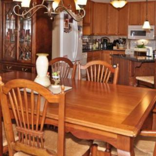 A cozy kitchen and dining area featuring wooden furniture and a chandelier.