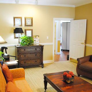A cozy living room featuring comfortable seating, a wooden coffee table, and decorative elements like plants and artwork.