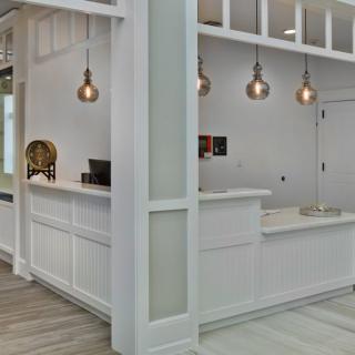 A modern reception area featuring a sleek counter and stylish pendant lighting.