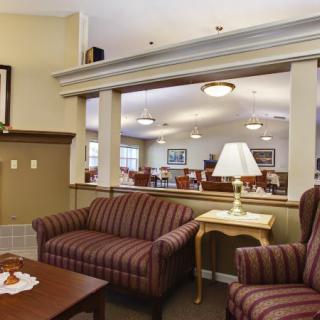 Comfortable seating area in a lobby with sofas, a lamp, and a table.