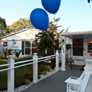 A charming house entrance decorated with blue balloons for an outdoor event.