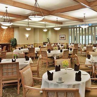 A spacious and elegantly designed restaurant dining area with neatly arranged tables and chairs.