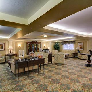 A spacious and well-lit hotel lobby with comfortable seating and a coffee station.