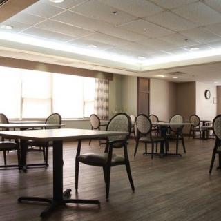 An empty dining room with tables and chairs arranged neatly.