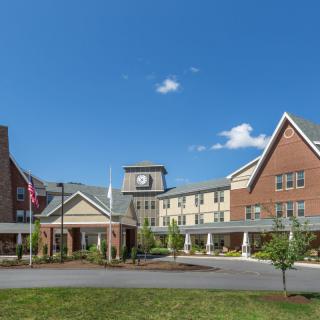 A large hotel building with a clock tower under a clear blue sky.