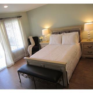 A cozy bedroom with a wooden bed, nightstands, and natural lighting.