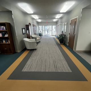 A view of a well-lit hallway featuring seating areas and decorative elements.