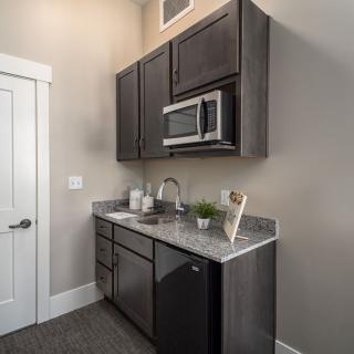 A modern kitchen setup featuring dark cabinets and a microwave.