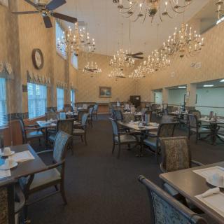 Spacious restaurant interior with elegant chandeliers and well-arranged dining tables.