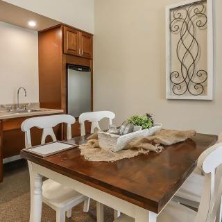 A cozy dining area with a wooden table and white chairs, featuring elegant wall art and decorative elements.