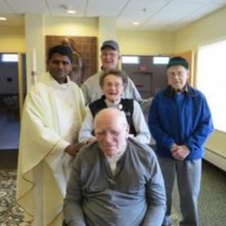 A group of people in a casual indoor setting, smiling for the photo.
