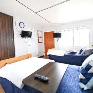 A cozy hotel room featuring two beds, a TV, and natural light from the window.