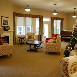 A cozy living room with a fireplace, comfortable seating, and festive decorations.