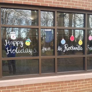 Festive holiday greetings displayed on windows, spreading cheer in the community.
