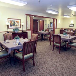 A cozy dining room setup with multiple tables and chairs, featuring elegant decor.