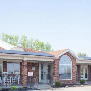 A brick building with large windows and a porch area.