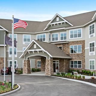 A residential building with a flagpole and entrance area.