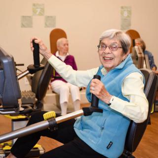 Elderly individuals engaging in a group exercise session indoors, showcasing active and healthy lifestyles.
