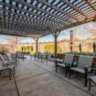 A spacious patio with a pergola and comfortable outdoor seating.