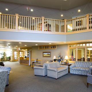 A spacious lobby with comfortable seating and a balcony overlooking the area.