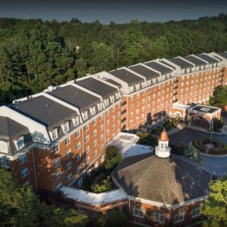 Aerial view of a large brick building surrounded by trees.