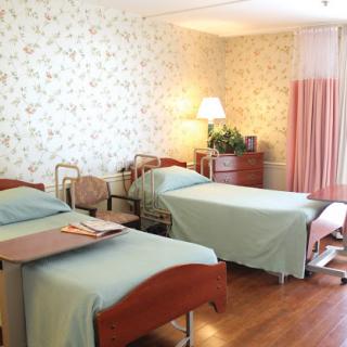 A well-lit hospital room featuring two patient beds, designed for comfort and care.