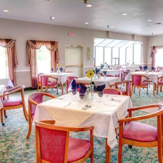 A well-lit dining room with neatly arranged tables and chairs, featuring elegant decor.