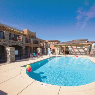 A sunny day at a luxurious resort with a sparkling outdoor pool.